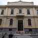 Il palazzotto, a due piani e di color crema, esibisce sei finestre inquadrate in una cornice bianca rettangolare decorata con elementi punzonati laterali e una piccola voluta sulla sommit, oltre a una porta-finestra balconata